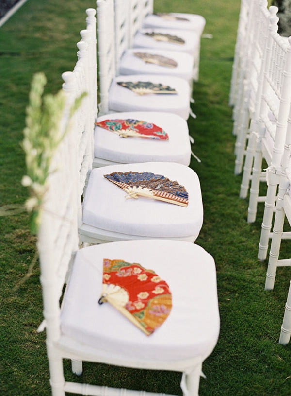 Brightly coloured fans placed on each chair at the wedding ceremony as a wedding favor for guests | Vicki Grafton Photography via Style Me Pretty