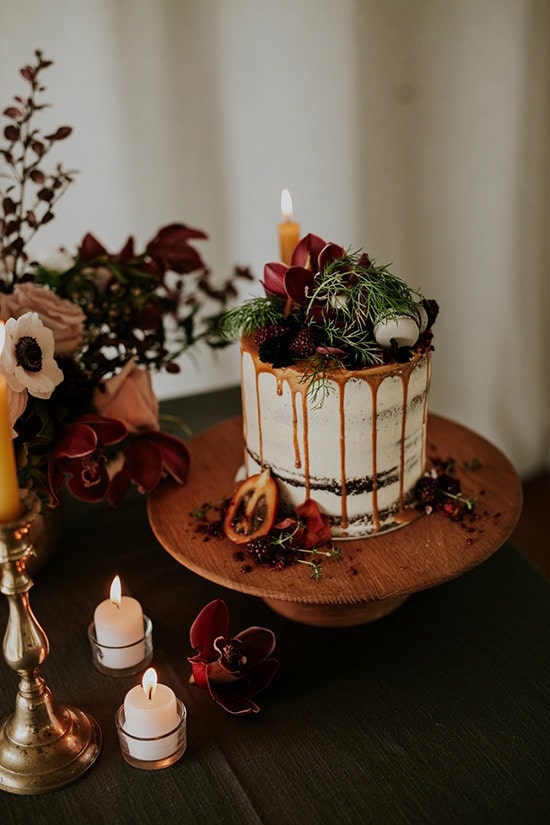 Bohemian wedding cake with caramel drip and burgundy flowers | Amy Kate Photography via Paper & Lace