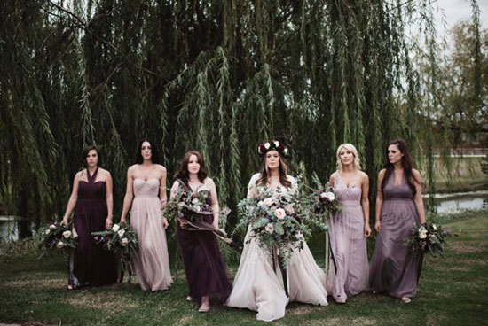 Modern romantic bride and bridesmaids wearing mismatched dresses in shades of purple | A Sea of Love via Junebug Weddings