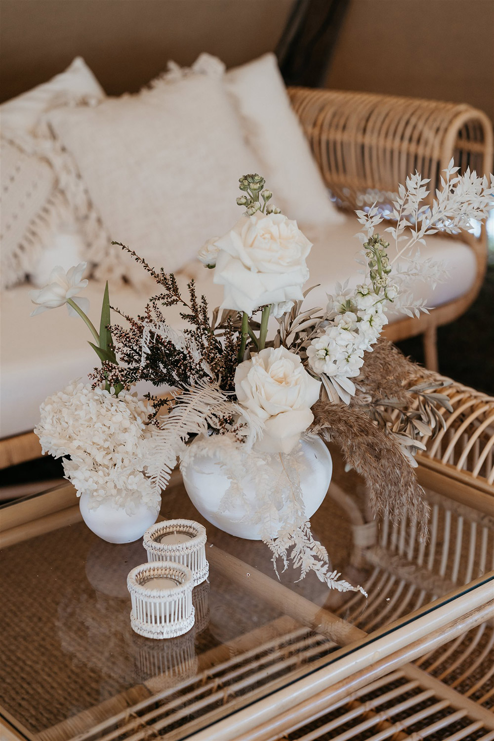 Outdoor Festival Bohemian Wedding Inspiration | ealight holders and fresh blooms in white vases. Potted plants in wicker baskets add lush greenery to this cool space. | Photography: Shae Estella Photo