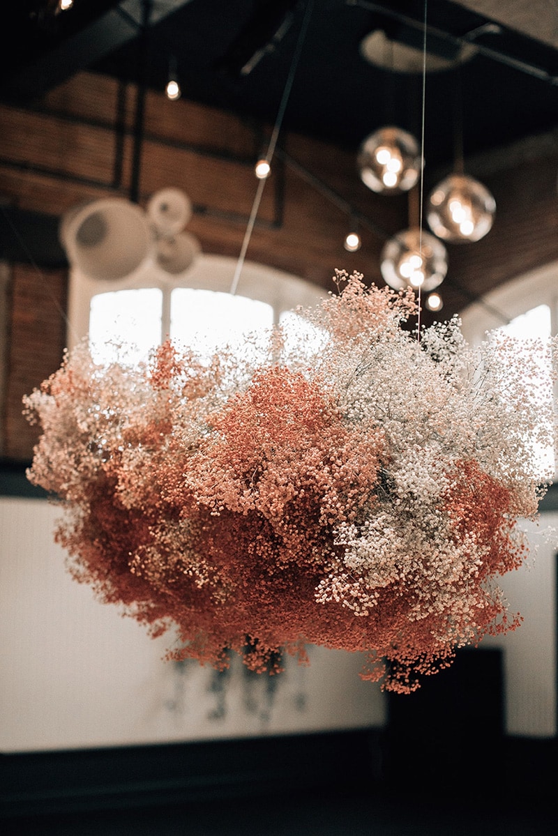Romantic Boho Terracotta Wedding Ideas | A cloud of spray painted baby's breath in white, clay and terracotta tones suspended above wedding reception tables. | Photography: Bethany Small via Mae&Co Creative