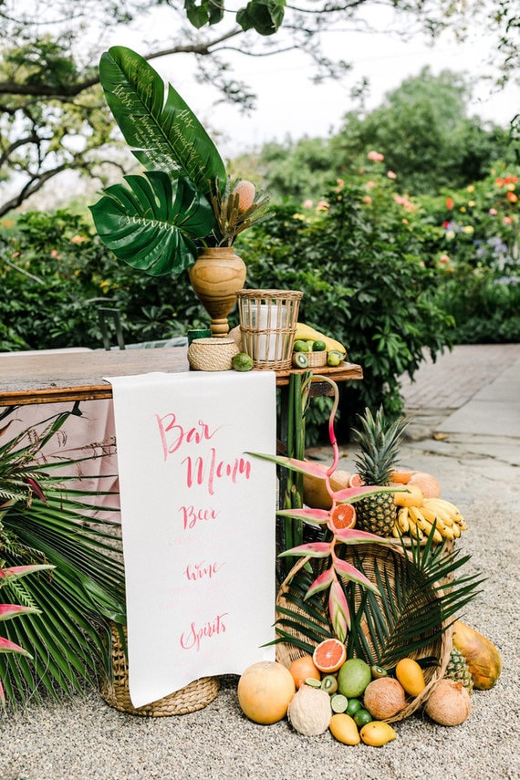 Bright tropical wedding bar with palm leaves and fruit | Anna Delores Photography via 100 Layer Cake