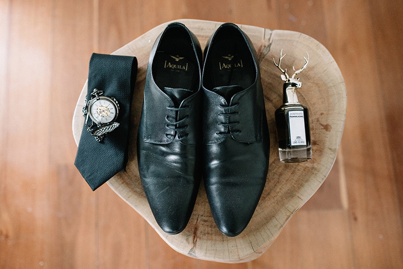 Groom accessories on wedding day including black leather shoes, cologne, tie and pocket watch | Nattnee Photography